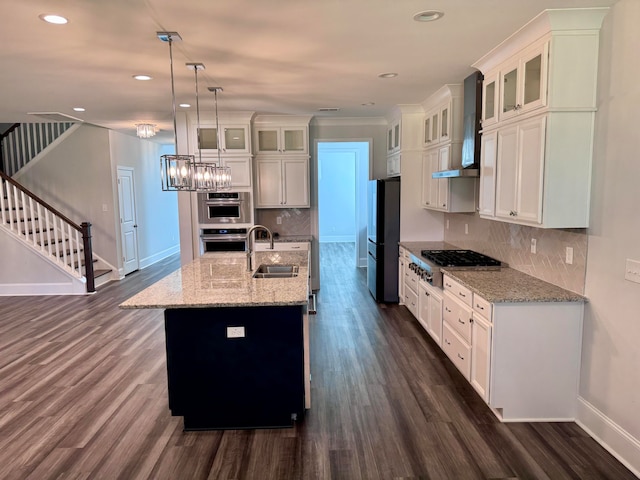 kitchen featuring a kitchen island with sink, white cabinets, and stainless steel appliances