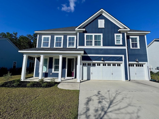 view of front of house featuring a front lawn, covered porch, and a garage