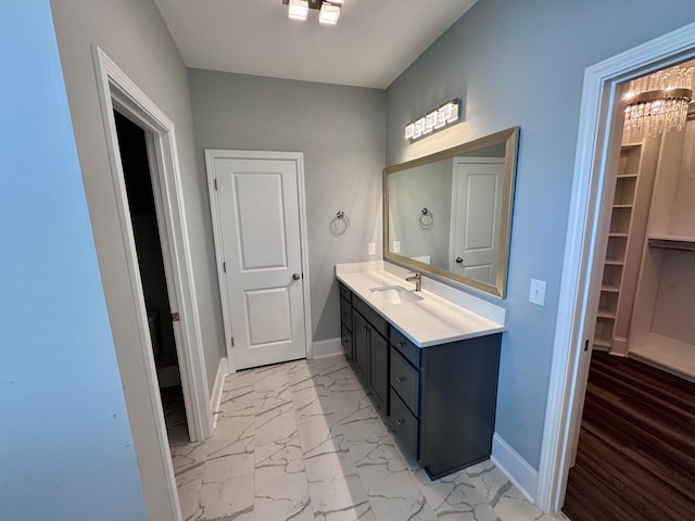 bathroom with hardwood / wood-style floors, vanity, and a notable chandelier