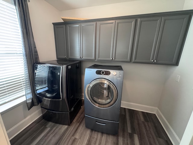 laundry area featuring washing machine and dryer, dark hardwood / wood-style flooring, and cabinets