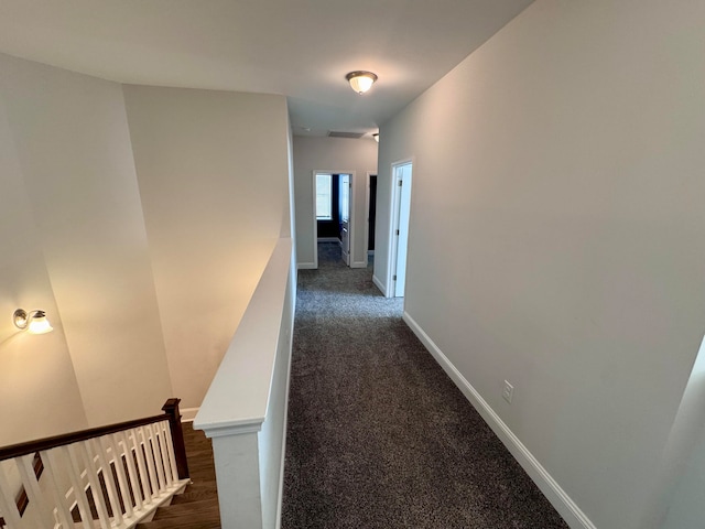 hallway featuring dark colored carpet