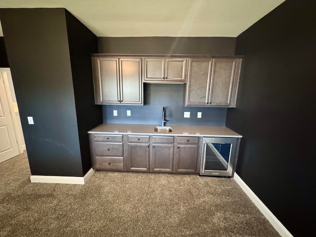 kitchen with carpet flooring, wine cooler, and sink