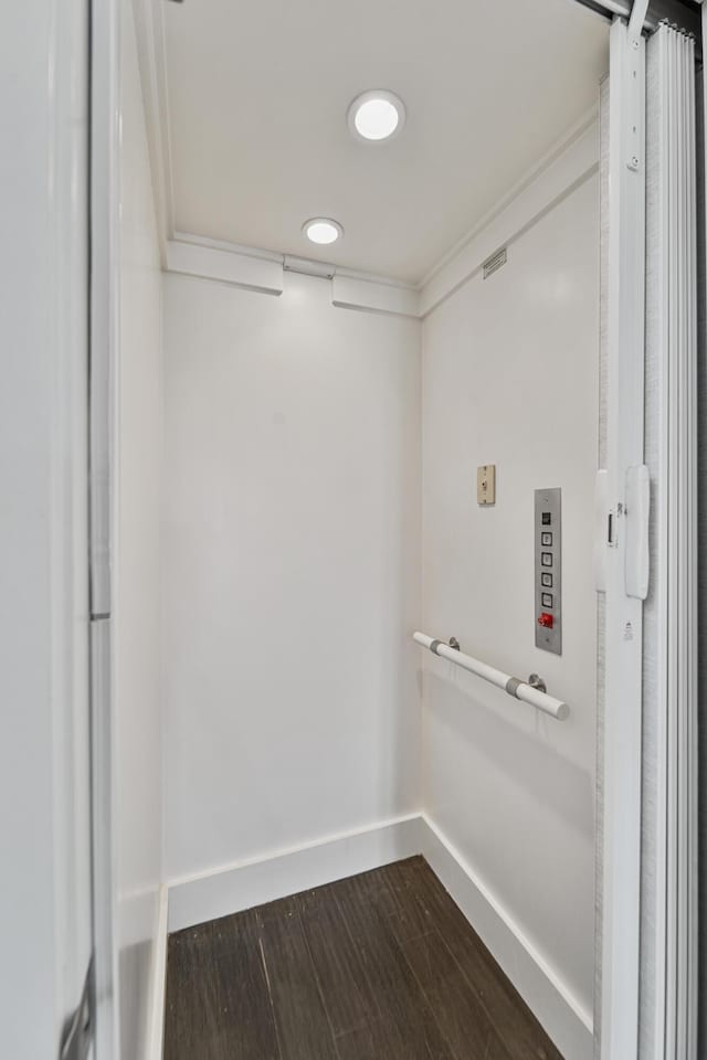 clothes washing area with baseboards and dark wood-style floors