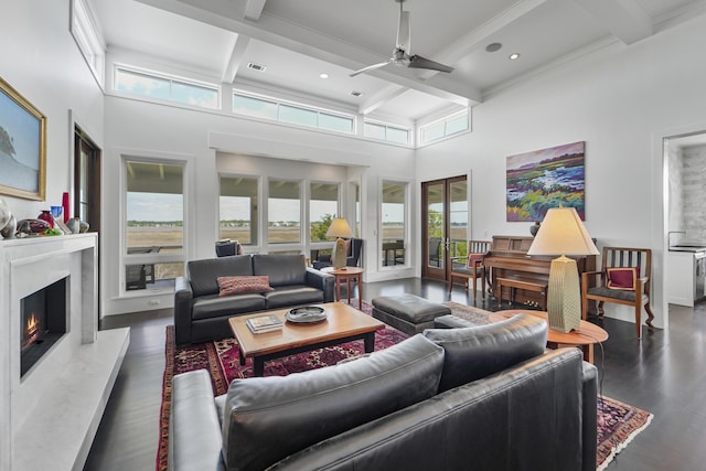 living room with wood finished floors, beam ceiling, ceiling fan, plenty of natural light, and a premium fireplace