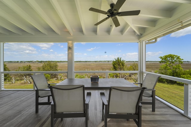sunroom / solarium with beam ceiling, a rural view, and wood finished floors