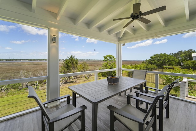 exterior space with outdoor dining space, ceiling fan, beam ceiling, and a rural view