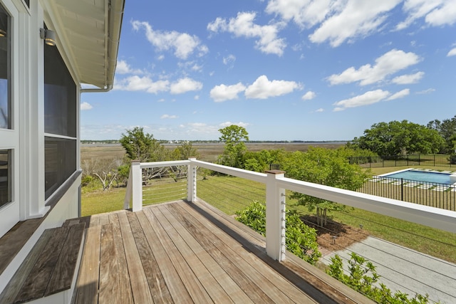 wooden terrace with a lawn, a rural view, and fence