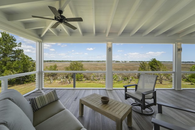 sunroom with beamed ceiling, a ceiling fan, and a wealth of natural light