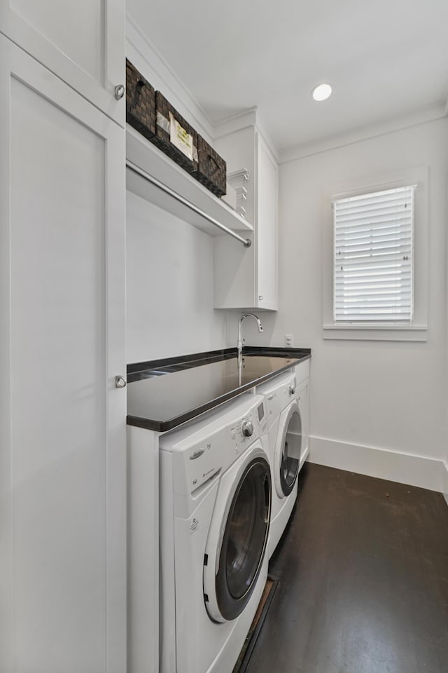 washroom featuring cabinet space, a sink, recessed lighting, baseboards, and washing machine and dryer