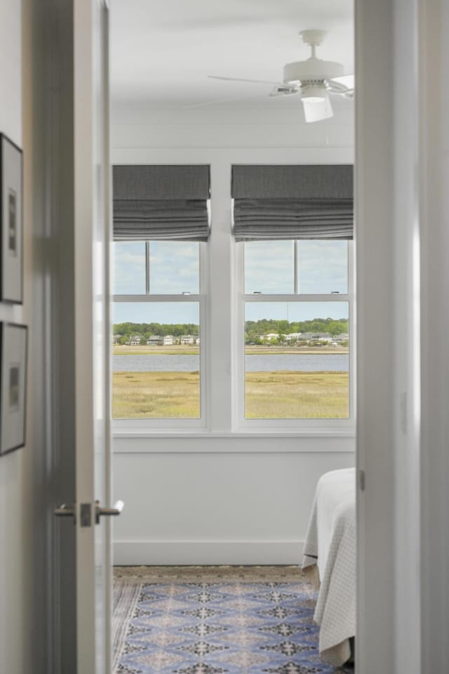 interior space with baseboards and a ceiling fan