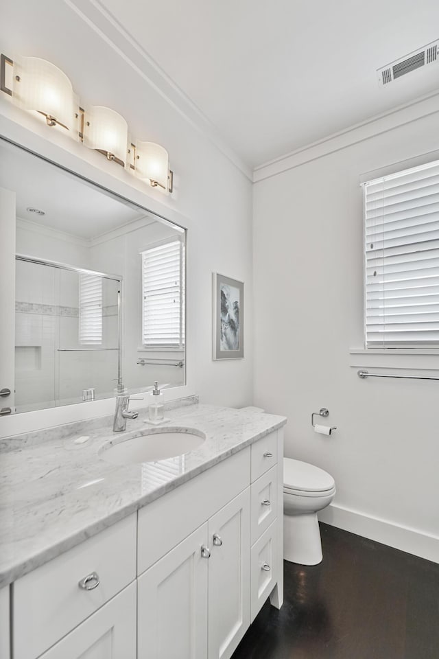 bathroom with crown molding, vanity, toilet, a shower stall, and visible vents