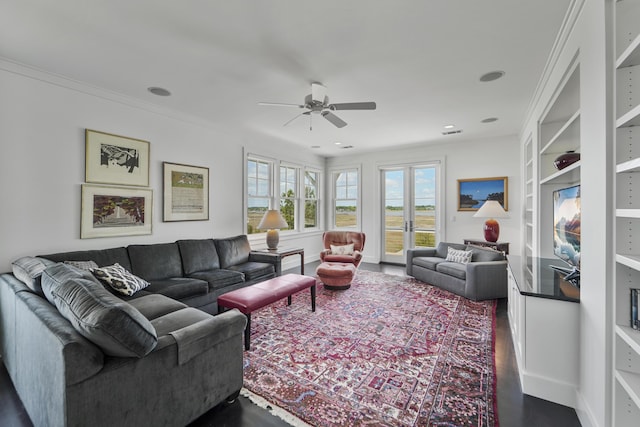 living area featuring baseboards, dark wood finished floors, ceiling fan, and built in shelves