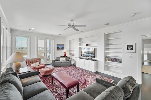 living room featuring ceiling fan, crown molding, built in shelves, baseboards, and recessed lighting