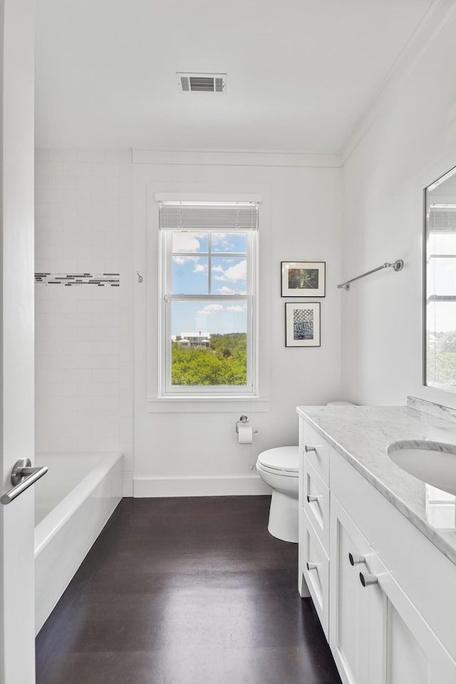 bathroom with vanity, toilet, baseboards, wood finished floors, and visible vents