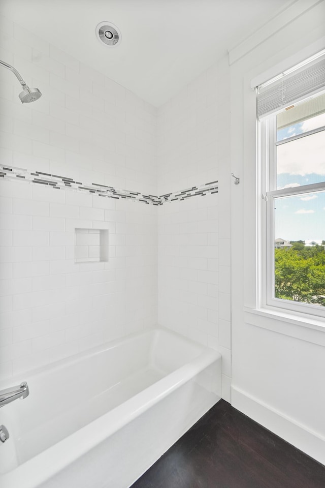 full bath featuring baseboards, bathing tub / shower combination, and wood finished floors