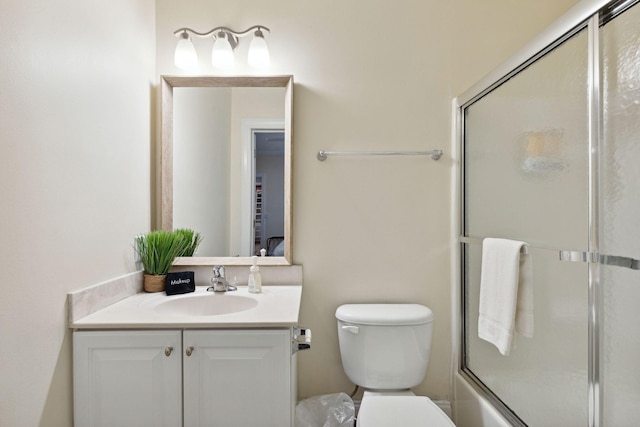 full bathroom featuring combined bath / shower with glass door, toilet, and vanity