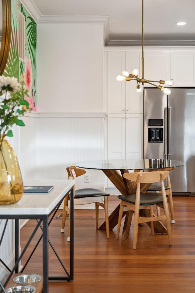 dining area with crown molding, an inviting chandelier, and dark hardwood / wood-style flooring