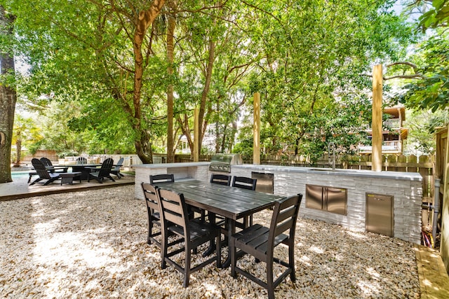 view of terrace with an outdoor kitchen and a grill