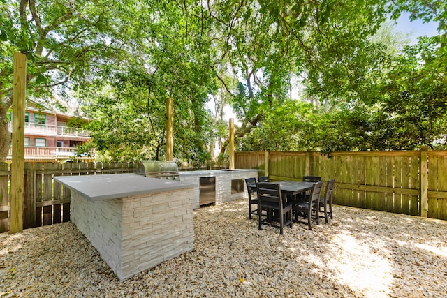 view of patio with a balcony, grilling area, and exterior kitchen