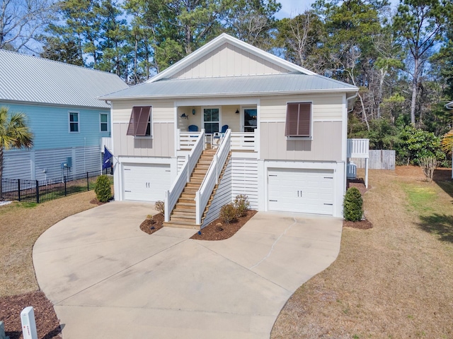 raised beach house featuring a porch, stairs, a garage, and board and batten siding