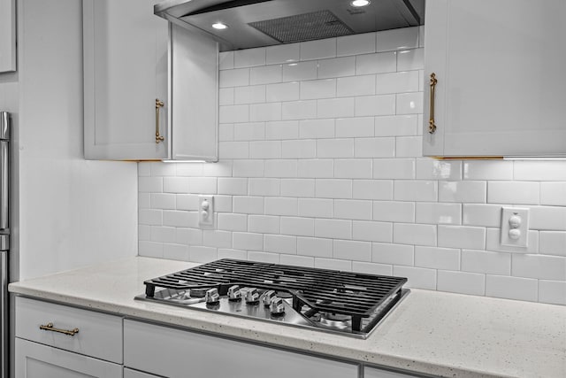 255 Saxony Loop, Summerville, SC 29486 - kitchen featuring stainless steel gas cooktop, custom exhaust hood, decorative backsplash, white cabinetry, and light stone counters