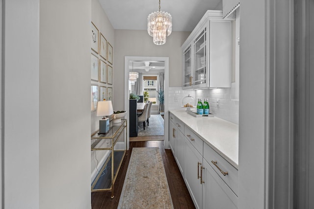 255 Saxony Loop, Summerville, SC 29486 - kitchen featuring a chandelier, dark wood-style floors, glass insert cabinets, decorative backsplash, and white cabinetry