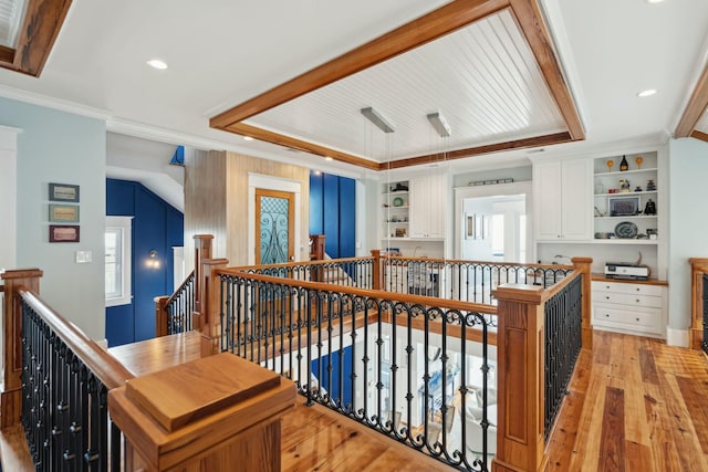 hallway with light wood finished floors, ornamental molding, an upstairs landing, and recessed lighting