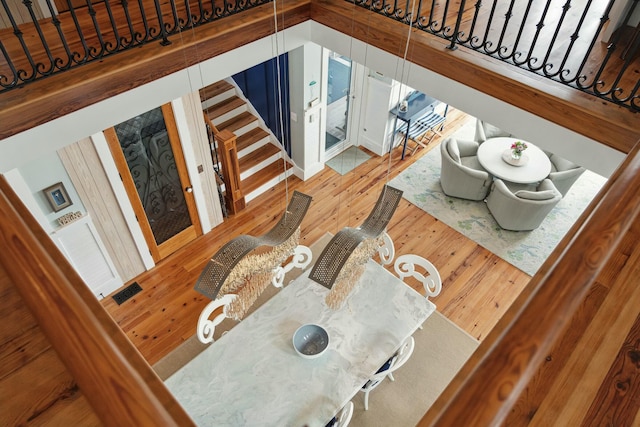 living room with stairs, visible vents, and wood finished floors