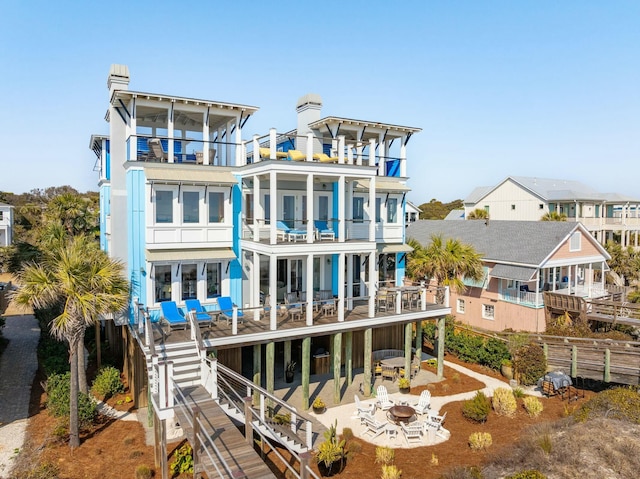 back of house with a balcony, a residential view, stairs, fence, and a patio area