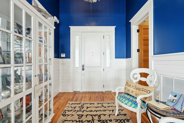 foyer entrance with wainscoting and wood finished floors