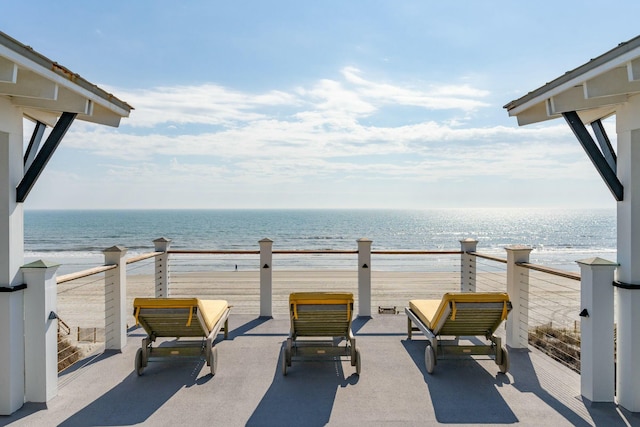 view of patio with a water view and a view of the beach