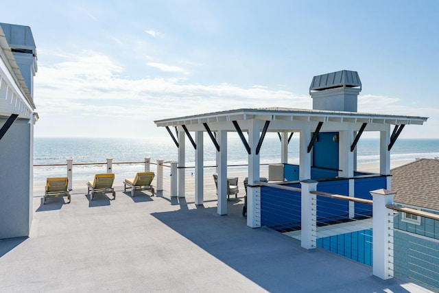 view of patio / terrace with a water view and a view of the beach