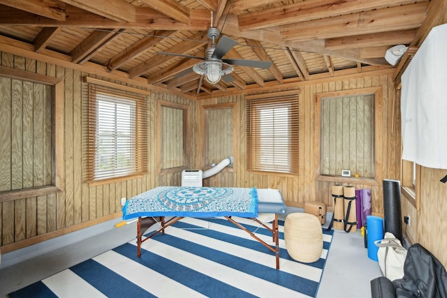 living area with wood walls and ceiling fan