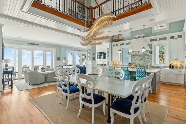 dining room with light wood finished floors and a high ceiling