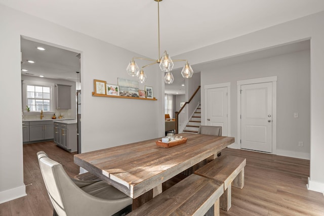 dining area with hardwood / wood-style flooring and a notable chandelier