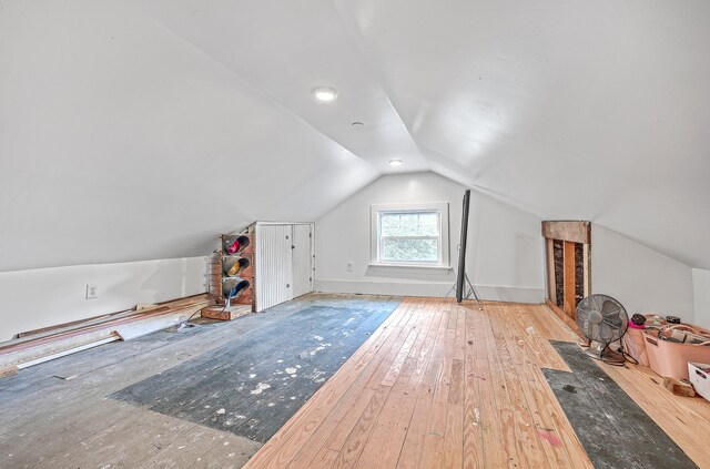 additional living space with vaulted ceiling and light wood-type flooring