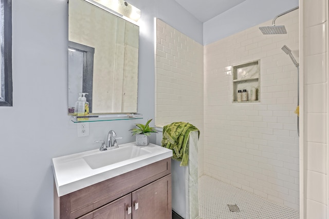 bathroom with vanity and a tile shower