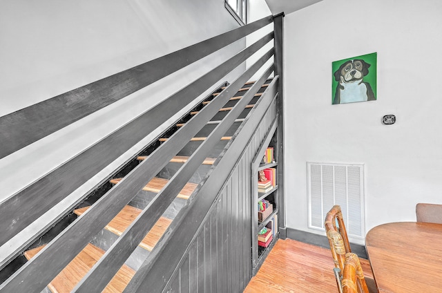 staircase with hardwood / wood-style floors