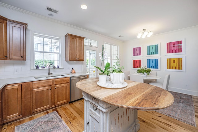 kitchen with decorative backsplash, dishwasher, crown molding, and a sink