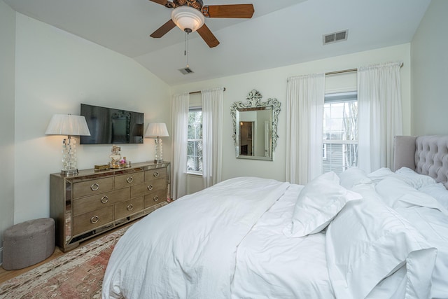 bedroom featuring lofted ceiling, light wood-style flooring, multiple windows, and visible vents