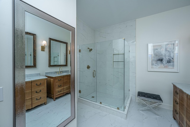 bathroom featuring two vanities, marble finish floor, a sink, a marble finish shower, and baseboards