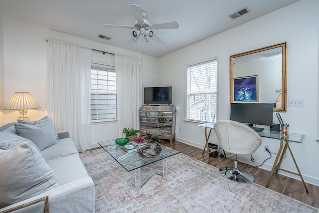 living room with plenty of natural light, wood finished floors, and visible vents