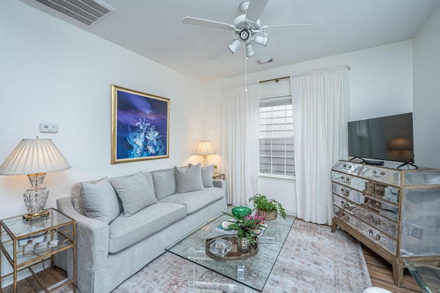 living room with visible vents, a ceiling fan, and wood finished floors