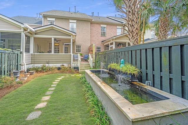 view of yard featuring fence, a deck, and a sunroom