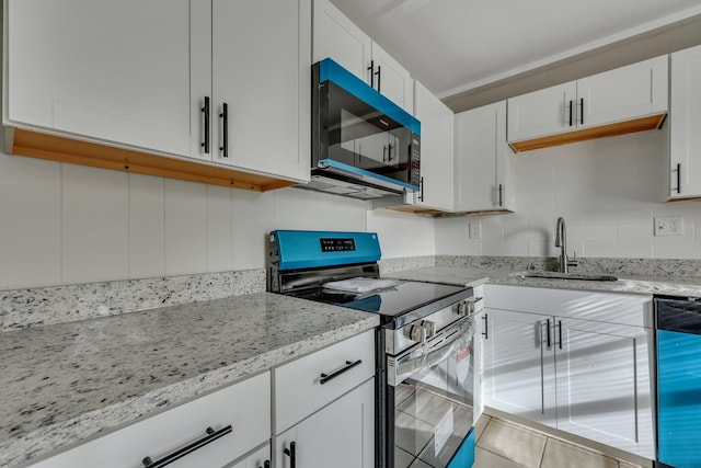 kitchen featuring sink, light stone countertops, tasteful backsplash, white cabinetry, and stainless steel appliances