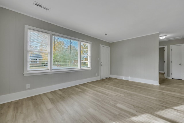 unfurnished living room featuring ornamental molding and light wood-type flooring