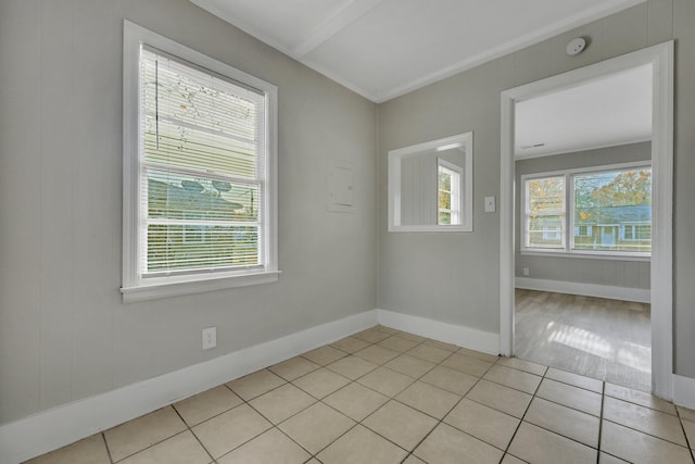 spare room with a wealth of natural light and light tile patterned flooring