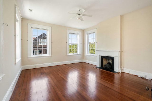 unfurnished living room featuring a ceiling fan, a wealth of natural light, hardwood / wood-style floors, and visible vents
