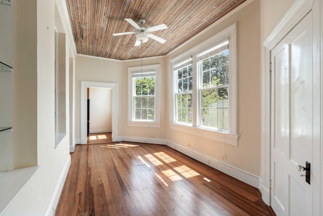 interior space with wood ceiling, crown molding, baseboards, ceiling fan, and hardwood / wood-style flooring