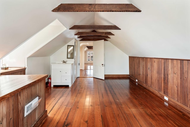 bonus room featuring a sink, lofted ceiling with beams, hardwood / wood-style floors, and visible vents